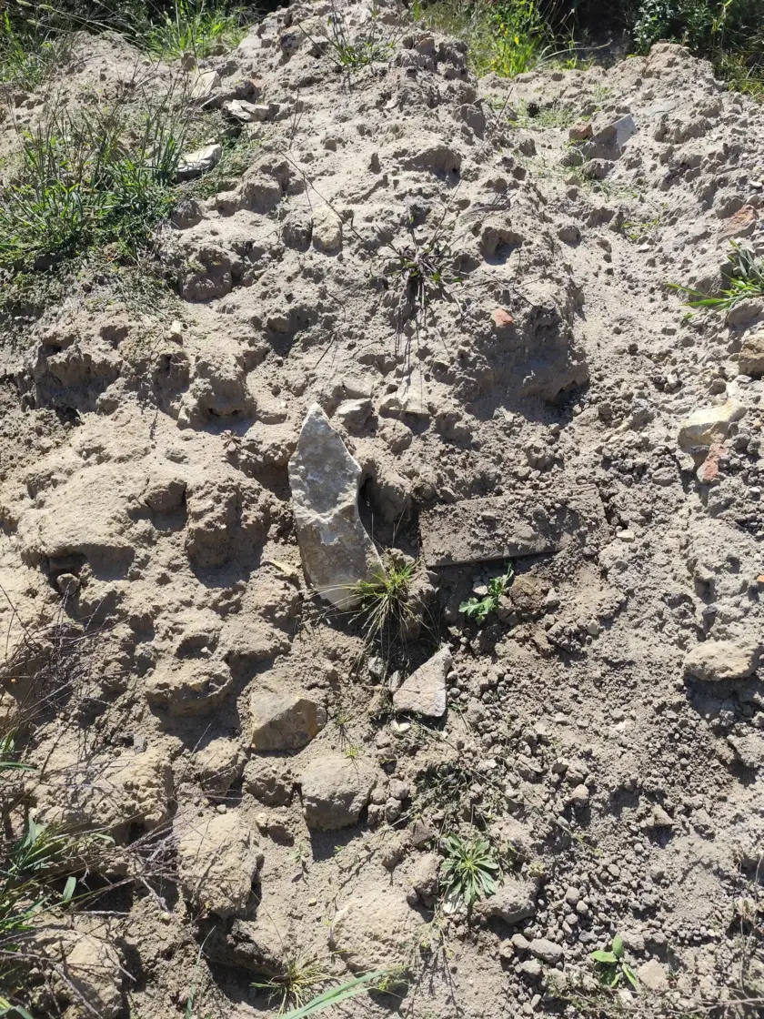 Gliniasta ziemia z gruzem i zbitymi bryłami jako przykład złego podłoża pod trawnik.